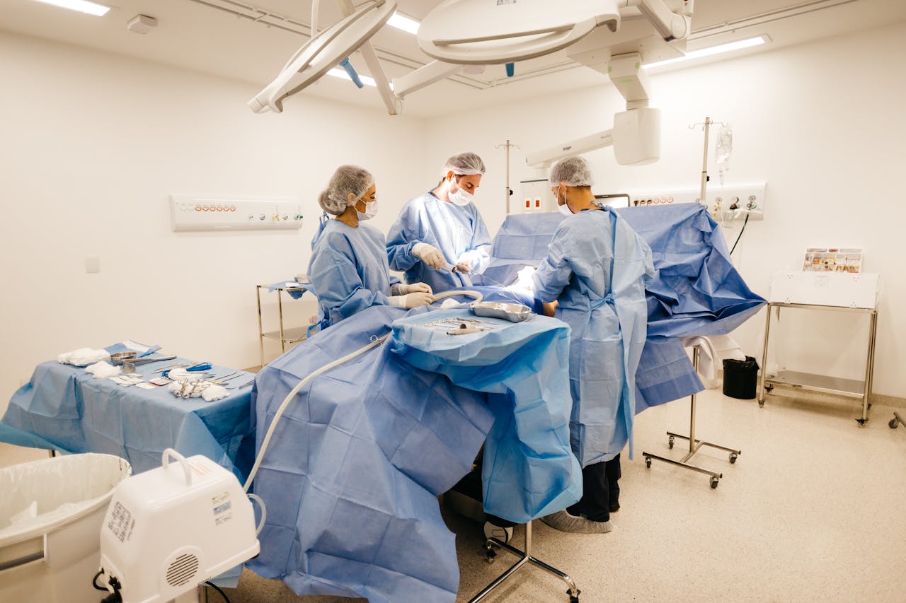 Medical professionals conduct surgery in a sterile, well-equipped operating room.