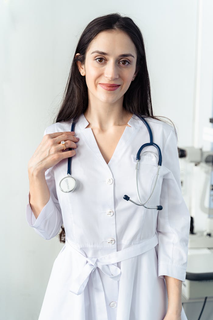 Portrait of a smiling female healthcare worker in a white coat with a stethoscope, embodying professionalism and care.